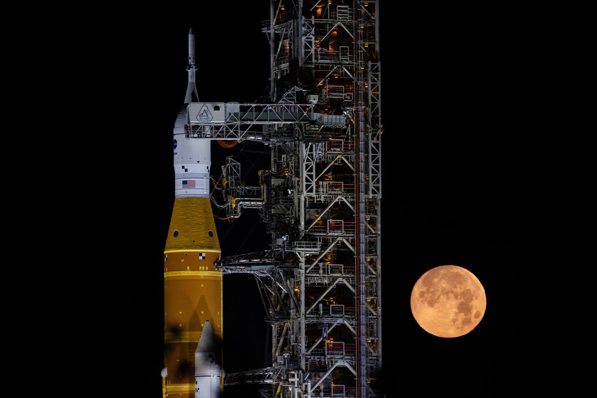 A full Moon is seen shining over NASA’s SLS (Space Launch System) and Orion spacecraft, atop the mobile launcher in the early hours of February 1, 2026. The rocket is currently at Launch Pad 39B at NASA’s Kennedy Space Center in Florida, as teams are preparing for a wet dress rehearsal to practice timelines and procedures for the launch of Artemis II.